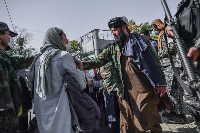 Taliban members stop women protesting for women's rights in Kabul on October 21, 2021. The Taliban violently cracked down on media coverage of a women's rights protest in Kabul on October 21 morning, beating several journalists. (Photo by Bulent Kilic/AFP Photo)