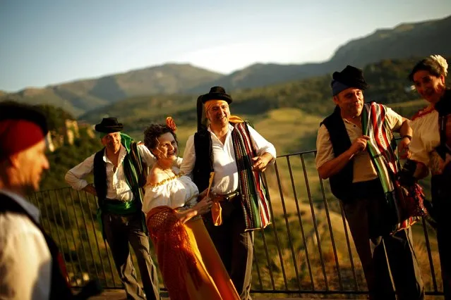 People dressed as bandits stand on a balcony at sunset as they participate in the third edition of “Ronda Romantica” (Romantic Ronda) in Ronda, southern Spain, May 16, 2015. (Photo by Jon Nazca/Reuters)