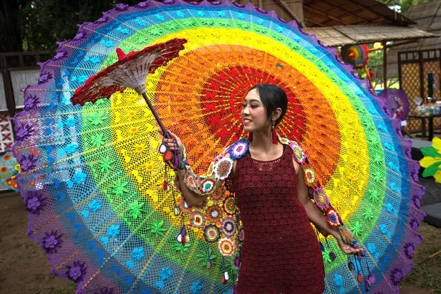 A model performs with knitting umbrella during the Indonesia Umbrella Festival 2021 at Balekambang Park on December 04, 2021 in Solo City, Indonesia. (Photo by Robertus Pudyanto/Getty Images)