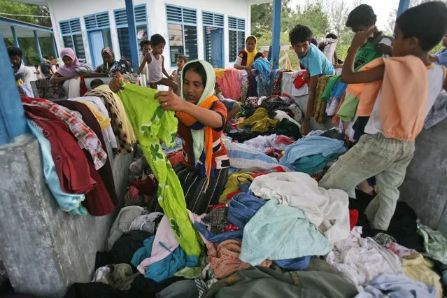 Ethnic Rohingya migrants sift through used clothing donated by local residence at a temporary shelter in Langsa, Aceh province, Indonesia, Saturday, May 16, 2015. (Photo by Binsar Bakkara/AP Photo)