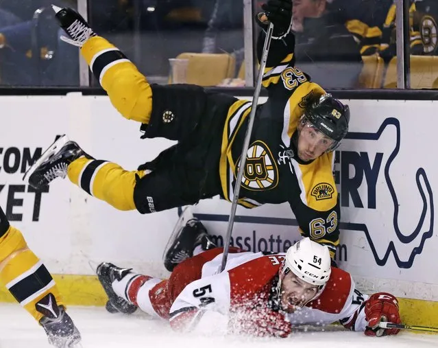 Boston Bruins left wing Brad Marchand, top, goes airborne after slamming Carolina Hurricanes defenseman Brett Pesce (54) to the ice during the second period of an NHL hockey game in Boston, Tuesday, April 5, 2016. (Photo by Charles Krupa/AP Photo)