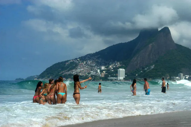 Bathers take photo with a stick-to-selfie on Ipanema beach, in the South Zone of Rio de Janeiro, Brazil on March 15, 2016. (Photo by Alessandro Buzas/Futura Press/Estadão Conteúdo)