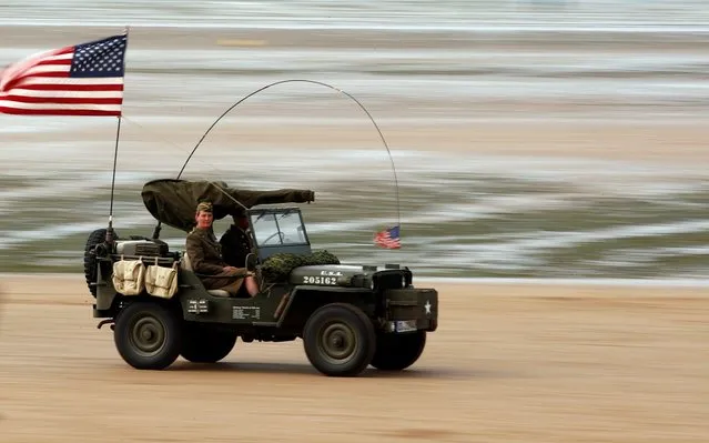 Enthusiasts enjoy a ride on a vintage army jeep during a re-enactment of D-Day landings in Arromanches, on the Normandy coast, France on June 3, 2019. (Photo by Christian Hartmann/Reuters)