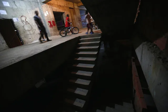 People walk along a corridor on the 10th floor of the “Tower of David” skyscraper in Caracas February 6, 2014. (Photo by Jorge Silva/Reuters)