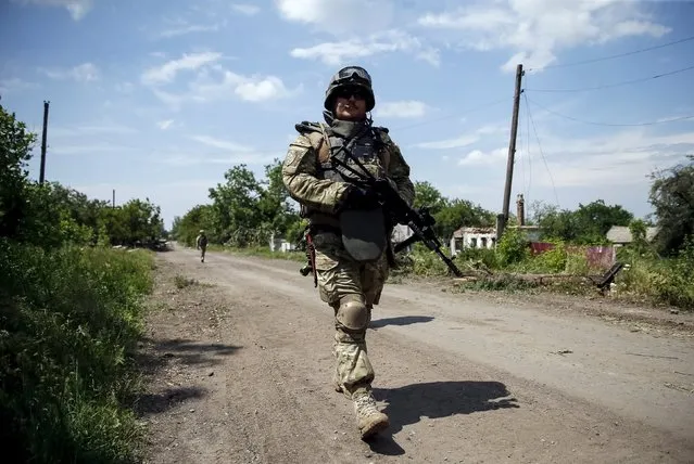 Members of the Ukrainian armed forces patrol the area in the town of Maryinka, eastern Ukraine, June 5, 2015. Ukraine's president told his military on Thursday to prepare for a possible "full-scale invasion" by Russia all along their joint border, a day after the worst fighting with Russian-backed separatists in months.  REUTERS/Gleb Garanich
