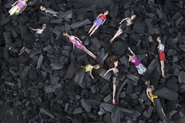 Charred-stained dolls placed on a bed of charcoal are part of artists’ installation placed at the front gate of Presidential House, in remembrance of the victims of a fire at a youth shelter in Guatemala City, Thursday, March 9, 2017. Hospital officials say the death toll in the Wednesday morning fire at the Virgin of the Assumption Safe Home has risen to 28 after several more girls died overnight of severe burns. (Photo by Luis Soto/AP Photo)