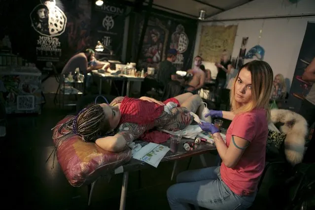 Tattoo artists work on clients during the second International Tattoo Festival in Sochi, Russia, April 23, 2016. (Photo by Kazbek Basayev/Reuters)