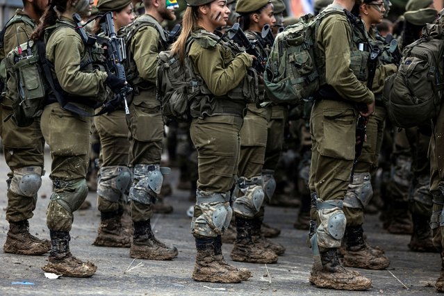 Members of Israel's coed Search and Rescue Brigade participate in an intensive march after which they will receive their brigade berets, in Latrun, Israel, on February 1, 2024. (Photo by Ronen Zvulun/Reuters)
