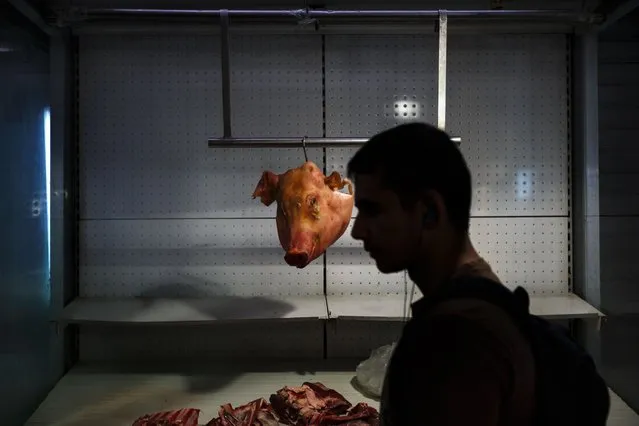 The head of a pig hangs from a hook at a market in central Athens, Saturday, June 27, 2015. Germany's vice chancellor says that a Greek referendum on the bailout talks could in principle make sense, but notes that it should be clear to voters what they will be deciding on. (Photo by Daniel Ochoa de Olza/AP Photo)