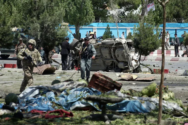Afghan and NATO security forces work at the site of a suicide attack in Kabul, Afghanistan, Tuesday, June 30, 2015. (Photo by Massoud Hossaini/AP Photo)