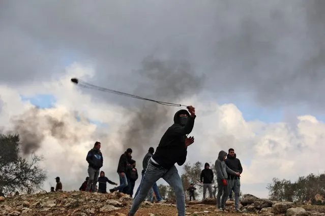 Palestinian protesters gather during clashes with Israeli security forces following a demonstration against settlements in the village of Beita in the occupied West Bank, on February 11, 2022. (Photo by Jaafar Ashtiyeh/AFP Photo)