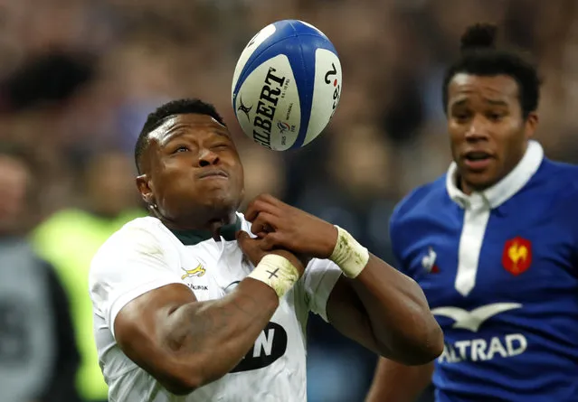 In this Saturday, November 10, 2018 file photo, South Africa's Aphiwe Dyantyi, left, attempts to catch the ball as France's Teddy Thomas runs in during their rugby union international at the Stade de France in Paris, France. South Africa wing Aphiwe Dyantyi, who won world rugby's breakthrough player award in 2018, says he has failed a doping test. (Photo by Christophe Ena/AP Photo/File)