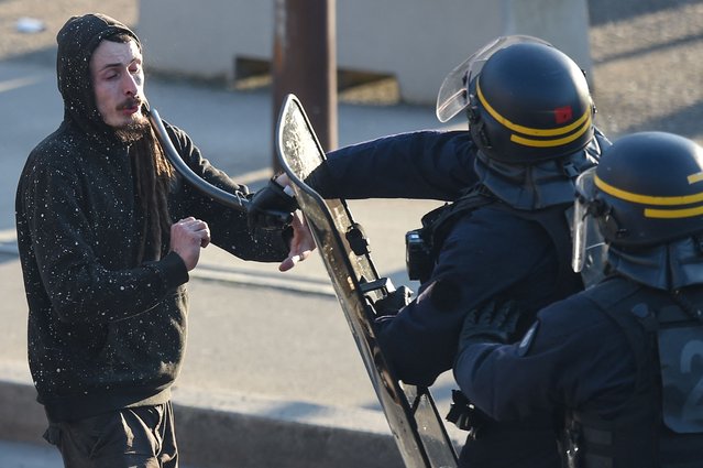 A protester receives a blow with a baton by a French riot policeman on the sidelines of a demonstration on the fourth day of nationwide rallies organised since the start of the year, against a deeply unpopular pensions overhaul, in Nantes on February 11, 2023. (Photo by Sebastien Salom-Gomis/AFP Photo)