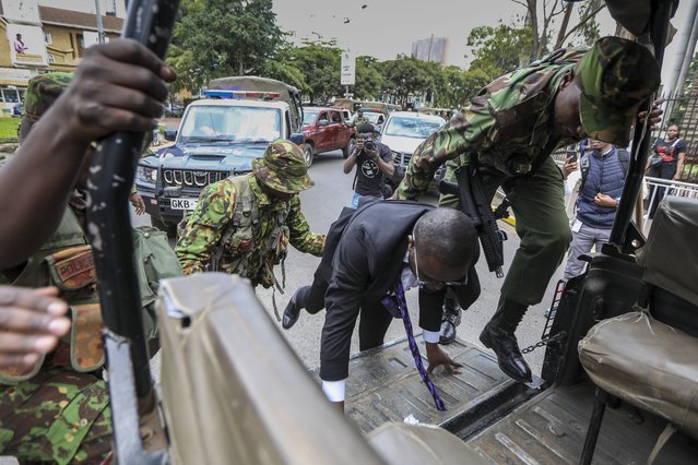 Kenya police officers arrest a lawyer (C) on suspicision of being one of the protesters who were marching towards the Parliament buildings during a protest to oppose a proposed Finance Bill 2024, in Nairobi, Kenya, 18 June 2024. According to protesters, the Bill is said to be punitive due to the new high taxes proposed that will increase the already high cost of living. The protest dubbed “Occupy Parliament” coincided with the tabling of the Bill in the House. The voting on the Bill is expected to be on 20 June. (Photo by Daniel Irungu/EPA)