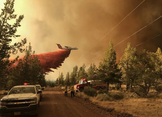 This photo provided by the Oregon Department of Forestry shows a firefighting tanker making a retardant drop over the Grandview Fire near Sisters, Ore., Sunday, July 11, 2021. The wildfire doubled in size to 6.2 square miles (16 square kilometers) Monday, forcing evacuations in the area, while the state's biggest fire continued to burn out of control, with containment not expected until November. (Photo by Oregon Department of Forestry via AP Photo)