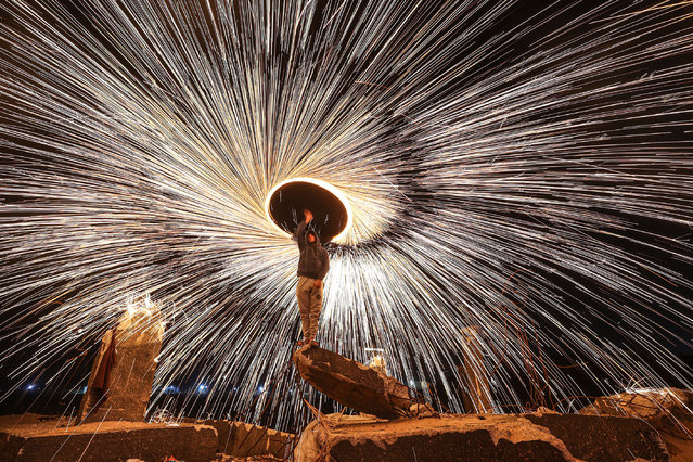 Palestinians perform to amuse people with a wire which ignites sparks during the Islamic holy fasting month of Ramadan, on April 03, 2023 in Gaza City, Gaza. (Photo by Mustafa Hassona/Anadolu Agency via Getty Images)