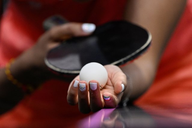 A detailed view of India's Manika Batra's nails painted with the Indian flag and Olympic Rings as she prepares to serve the ball during her women's table tennis singles match in the team quarter-finals between India and Germany at the Paris 2024 Olympic Games at the South Paris Arena in Paris on August 7, 2024. (Photo by Wang Zhao/AFP Photo)