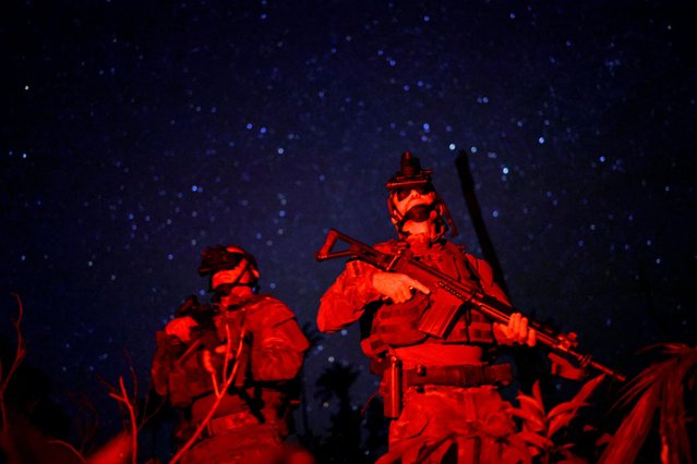 Felipe Finger (R), the head of the Special Inspection Group from the Brazilian Institute of Environment and Renewable Natural Resources (IBAMA), and his colleague use night vision goggles during an operation against illegal mining in Yanomami Indigenous land, Roraima state, Brazil, on December 4, 2023. (Photo by Ueslei Marcelino/Reuters)