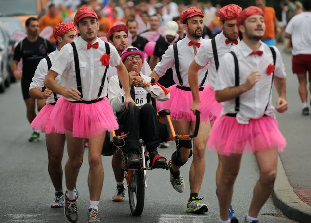 People take part in the “Foulee du Festayres” foot race between Biarritz and Bayonne in Biarritz, southwestern France on July 29, 2015, on the first day of the 79th Bayonne festival. This year's festival will run until August 2, 2015. (Photo by Gaizka Iroz/AFP Photo)