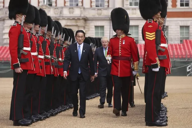 Britain's Prime Minister Boris Johnson, centre background, walks with Japan's Prime Minister Fumio Kishida as they review an Honour Guard, during a welcoming ceremony in Westminster, London, Thursday, May 5, 2022. The leaders of Britain and Japan met in London to announce a new defense agreement against the backdrop of the war in Ukraine. (Photo by Dan Kitwood/Pool Photo via AP Photo)