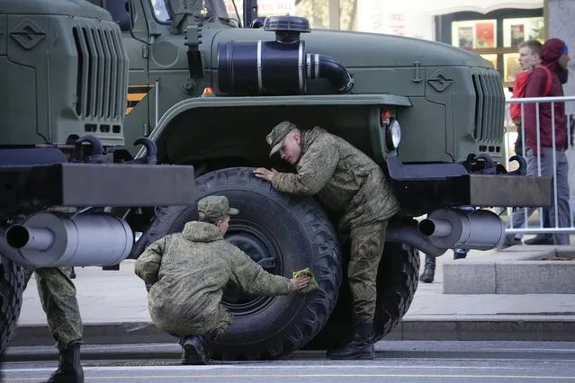 Russian soldiers wipe from dust their military vehicle prior to a rehearsal for the Victory Day military parade in Moscow, Russia, Wednesday, May 4, 2022. The parade will take place at Moscow's Red Square on May 9 to celebrate 77 years of the victory in WWII. (Photo by Alexander Zemlianichenko/AP Photo)