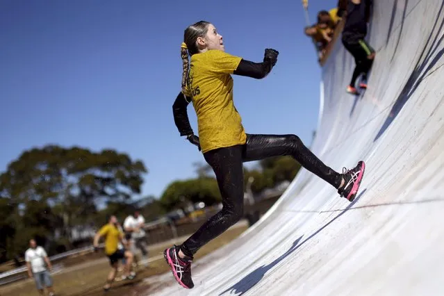 A woman runs up an obstacle during the Bravus Race competition in Brasilia, August 2, 2015. (Photo by Ueslei Marcelino/Reuters)