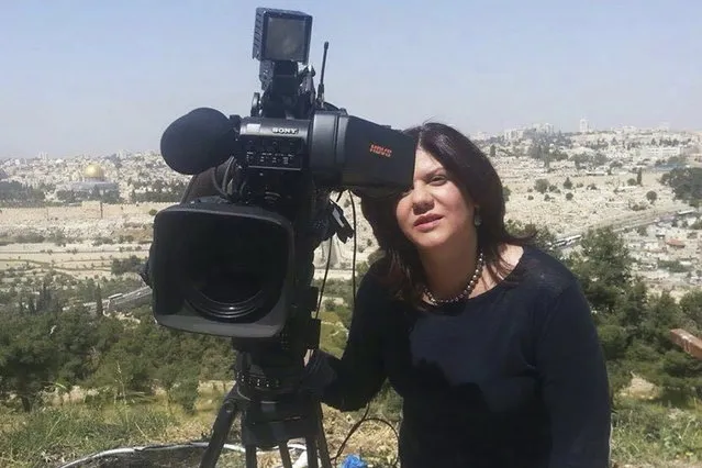 In this undated photo provided by Al Jazeera Media Network, Shireen Abu Akleh, a journalist for Al Jazeera network, stands next to a TV camera in an area where the Dome of the Rock shrine at Al-Aqsa Mosque in the Old City of Jerusalem is seen at left in the background. Abu Akleh, a well-known Palestinian female reporter for the broadcaster's Arabic language channel, was shot and killed while covering an Israeli raid in the occupied West Bank town of Jenin early Wednesday, May 11, 2022. (Photo by Al Jazeera Media Network via AP Photo)