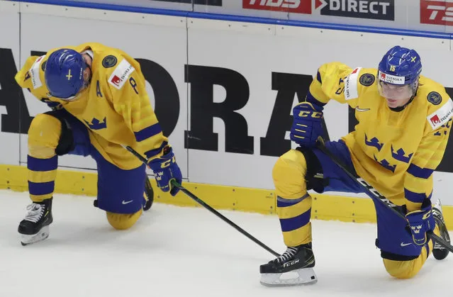 Sweden's Rasmus Sandin, left, and Sweden's Oskar Back, right, kneel on ice after loosing the U20 Ice Hockey Worlds semifinal match between Sweden and Russia in Ostrava, Czech Republic, Saturday, January 4, 2020. (Photo by Petr David Josek/AP Photo)