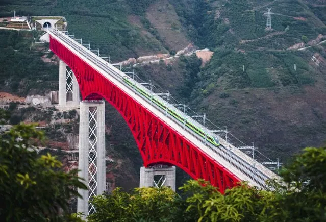 In this photo released by Xinhua News Agency, an electric multiple unit (EMU) train of the China-Laos Railway crosses a major bridge over the Yuanjiang River in southwestern China's Yunnan Province, Friday, December 3, 2021. The China Laos railway is one of hundreds of projects under Beijing's Belt and Road Initiative to build ports, railways and other facilities across Asia, Africa and the Pacific. (Photo by Wang Guansen/Xinhua via AP Photo)