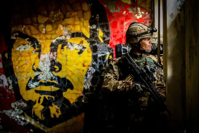 A Royal Marine seen during a training exercise on the background of mosaic of Vladimir Lenin on the wall of the ruin of the army club on a territory of ex-Soviet secret army compound “Skrunda-1”, which now is a ghost town and Cold War era museum in Skrunda, Latvia on June 28, 2019. (Photo by Dean Nixon/PA Wire Press Association)