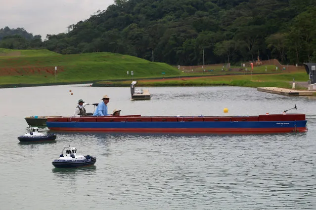 A Panama Canal pilot maneuvers a miniature tugboat as he sits on a scale cargo boat during a training day at the scale model maneuvering training facility of the Panama Canal, a day before the inauguration of the Panama Canal Expansion project on the outskirts of Panama City, in Panama June 25, 2016. (Photo by Alberto Solis/Reuters)