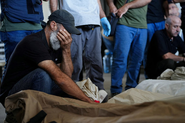 A mourner reacts near the bodies of people who were killed in an Israeli airstrike that destroyed the municipal headquarters in Nabatieh on Wednesday, during a collective funeral held for 13 people in Nabatieh, southern Lebanon, on October 18, 2024. (Photo by Mohammed Yassin/Reuters)