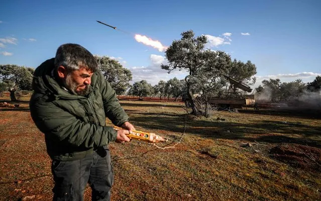 A Syrian rebel fighter remotely-fires a rocket from a truck-mounted launcher at a position in the countryside of Idlib towards regime forces positions in the southern countryside of Syria's Aleppo province on February 10, 2020. (Photo by Omar Haj Kadour/AFP Photo)