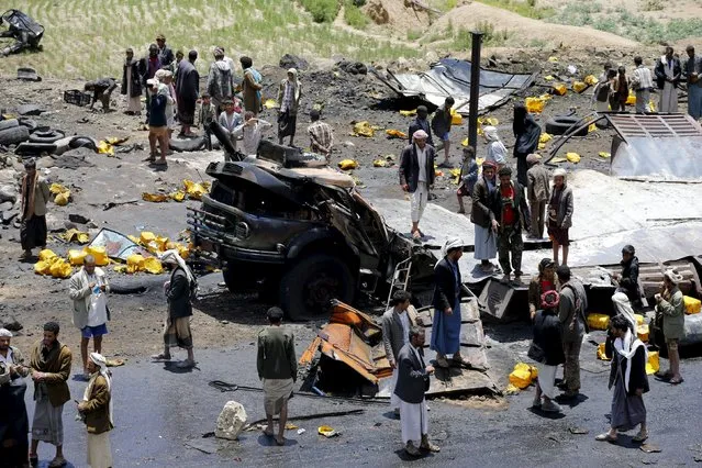 People gather at the site of a Saudi-led air strike that targeted a truck loaded with cooking oil canisters in Nqeel Yaslih near Yemen's capital Sanaa August 17, 2015. (Photo by Khaled Abdullah/Reuters)