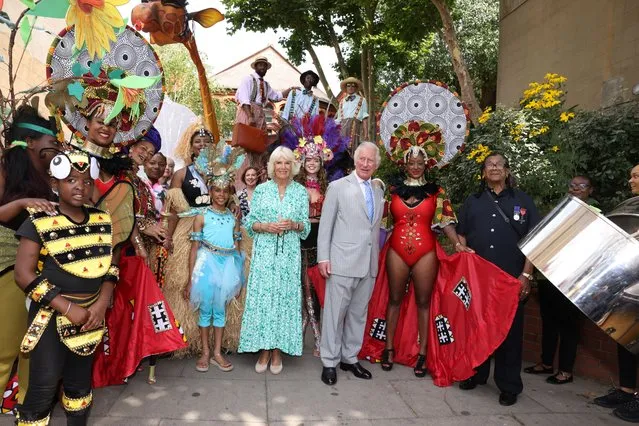 Britain's Prince Charles, Prince of Wales and Britain's Camilla, Duchess of Cornwall pose for pictures with performers as they attend a “mini-Carnival” display in the courtyard meeting at The Tabernacle, in London, on July 13, 2022 This August will be the first time the Carnival has been held since 2019 due to the pandemic. (Photo by Ian Vogler/Pool via AFP Photo)