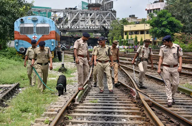 Police officials patrol with a sniffer dog on railway tracks ahead of India's Independence Day celebrations in Guwahati, August 12, 2017. (Photo by Anuwar Hazarika/Reuters)