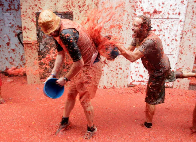 Revellers play with tomato pulp during the annual Tomatina festival in Bunol near Valencia, Spain on August 30, 2017. (Photo by Heino Kalis/Reuters)