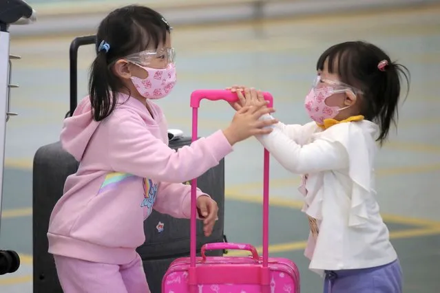 Young passengers wear face masks to protect against the coronavirus as they arrive at the Hong Kong airport, Monday, March 23, 2020. (Photo by Kin Cheung/AP Photo)