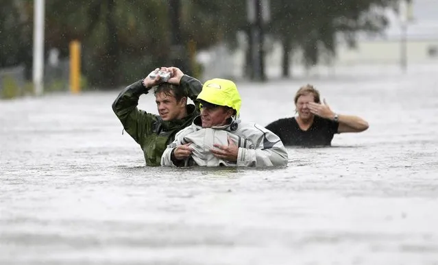 Chuck Cropp, his son Piers and wife Liz wade through floodwaters in New Orleans. La., on Aug. 29. (Photo by David J. Phillip/AP)