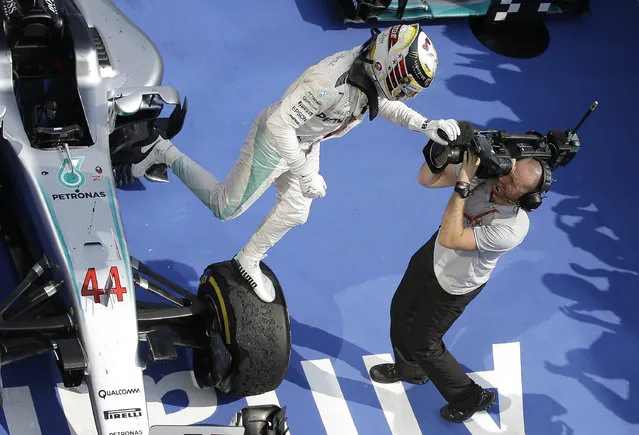 Mercedes driver Lewis Hamilton of Britain jumps off his car to celebrate after winning the Hungarian Formula One Grand Prix at the Hungaroring racetrack near Budapest, Hungary, Sunday, July 24, 2016. (Photo by Luca Bruno/AP Photo)