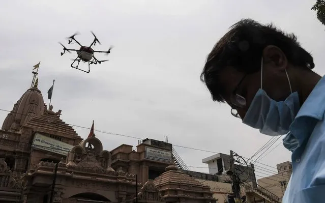 A drone sprays disinfectant chemicals to sanitise an area during a government-imposed nationwide lockdown as a preventive measure against the COVID-19 coronavirus, in New Delhi on April 14, 2020. (Photo by Prakash Singh/AFP Photo)