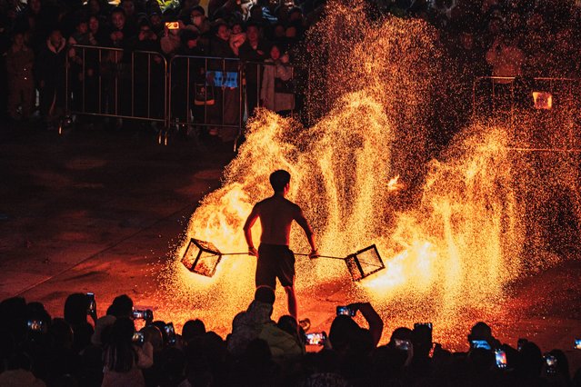 A folk artist shakes iron nets with hot charcoals to create sparks during Huohu (fire pot) performance at a China-Chic fireworks show on January 4, 2025 in Chengdu, Sichuan Province of China. (Photo by VCG/VCG via Getty Images)
