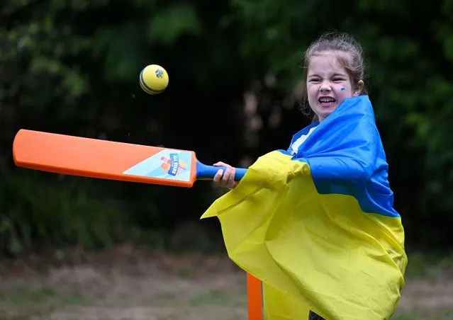 A young girl dressed in a Ukrainian flag has a go at cricket at the Ukrainian Independence Day - Family Event put on by Exeter Conversation Cafe at Poltimore House, on August 24, 2022 in Exeter, England. (Photo by Finnbarr Webster/Getty Images)