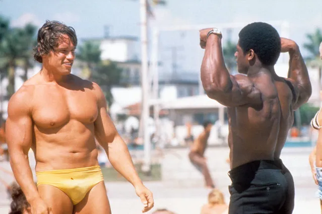 Austrian Bodybuilder Arnold Schwarzenegger admires another bodybuilder at Muscle Beach in Venice in August 1977 in Los Angeles, California. (Photo by Michael Ochs Archives/Getty Images)