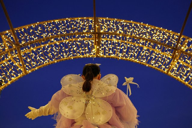 A person wearing a costume stands while welcoming visitors at a festive park ahead of Christmas in Dubai, United Arab Emirates on December 23, 2023. (Photo by Amr Alfiky/Reuters)