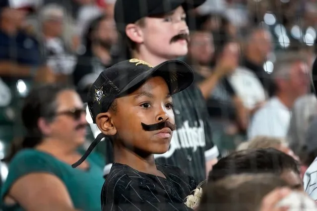 Two young Chicago White Sox baseball fans wear mustaches on Dylan Cease mustache night before a baseball game between the White Sox and the Cleveland Guardians, in Chicago on September 20, 2022. (Photo by Charles Rex Arbogast/AP Photo/Rex Features/Shutterstock)