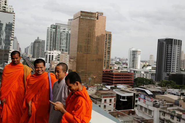 Buddhist monks stand in a terrace of a shopping mall overlooking Bangkok, Thailand  August 14, 2016. (Photo by Jorge Silva/Reuters)