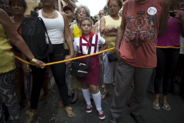 A child waits for the beginning of the annual procession of Our Lady of Charity, the patron saint of Cuba, on the streets of downtown Havana, September 8, 2015. (Photo by Alexandre Meneghini/Reuters)