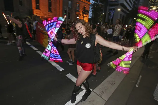 In this November 15, 2017, file photo, a woman twirls lights as members of the gay community and their supporters celebrate the result of a postal survey calling for gay marriage right in Sydney. Australians supported gay marriage in a postal survey that ensures Parliament will consider legalizing same-s*x weddings this year. (Photo by Rick Rycroft/AP Photo)