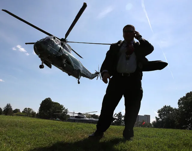 A member of the US Secret Service stands guard as Marine One carrying US President Barack Obama lands at Walter Reed National Medical Center in Bethesda, Maryland, USA, 26 August 2016. President Obama is visiting with wounded and ill soldiers and their families at the Medical Center. (Photo by Mark Wilson/EPA)